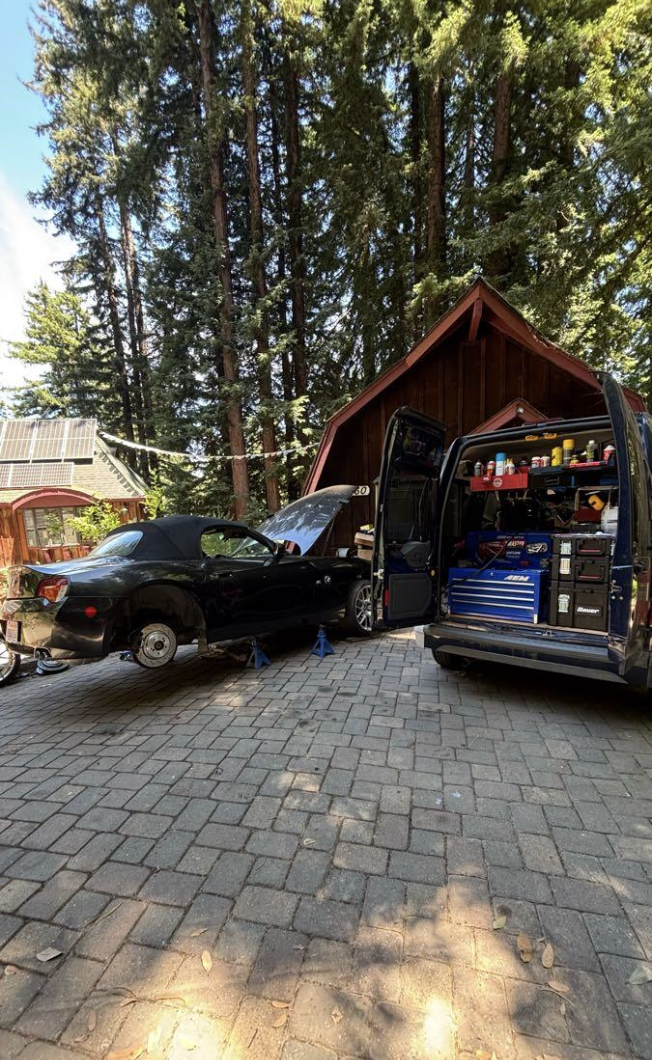 Mobile repair van parked among redwoods